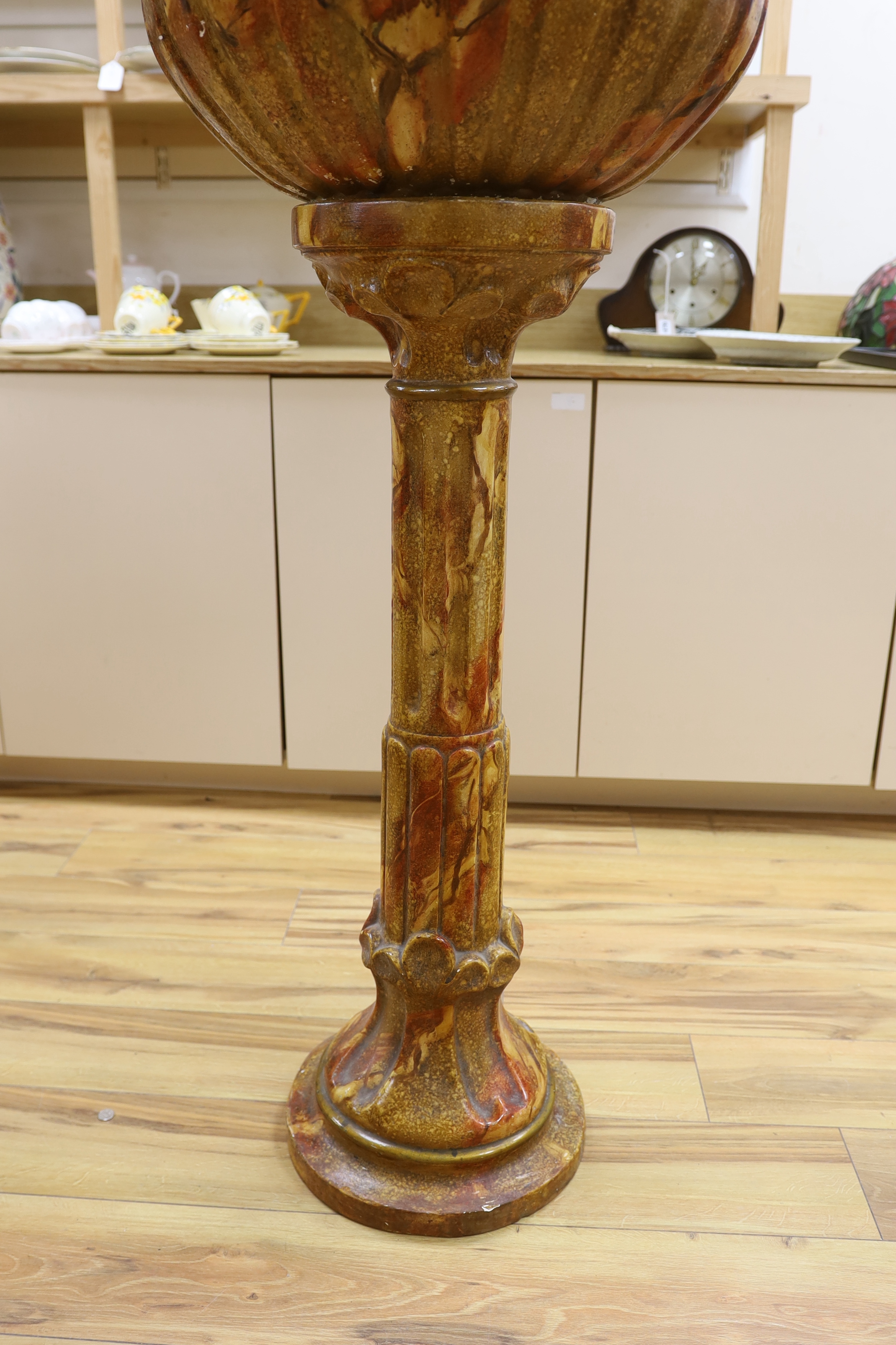 A large faux marble pottery jardiniere on stand, 126cm total height